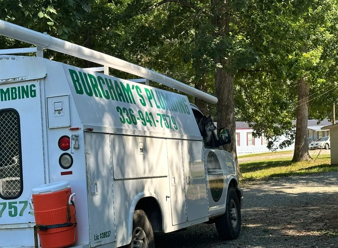 Burcham's Plumbing service work truck branded for Yadkinville NC residential and commercial plumbing, with dog mascot on vehicle wrap