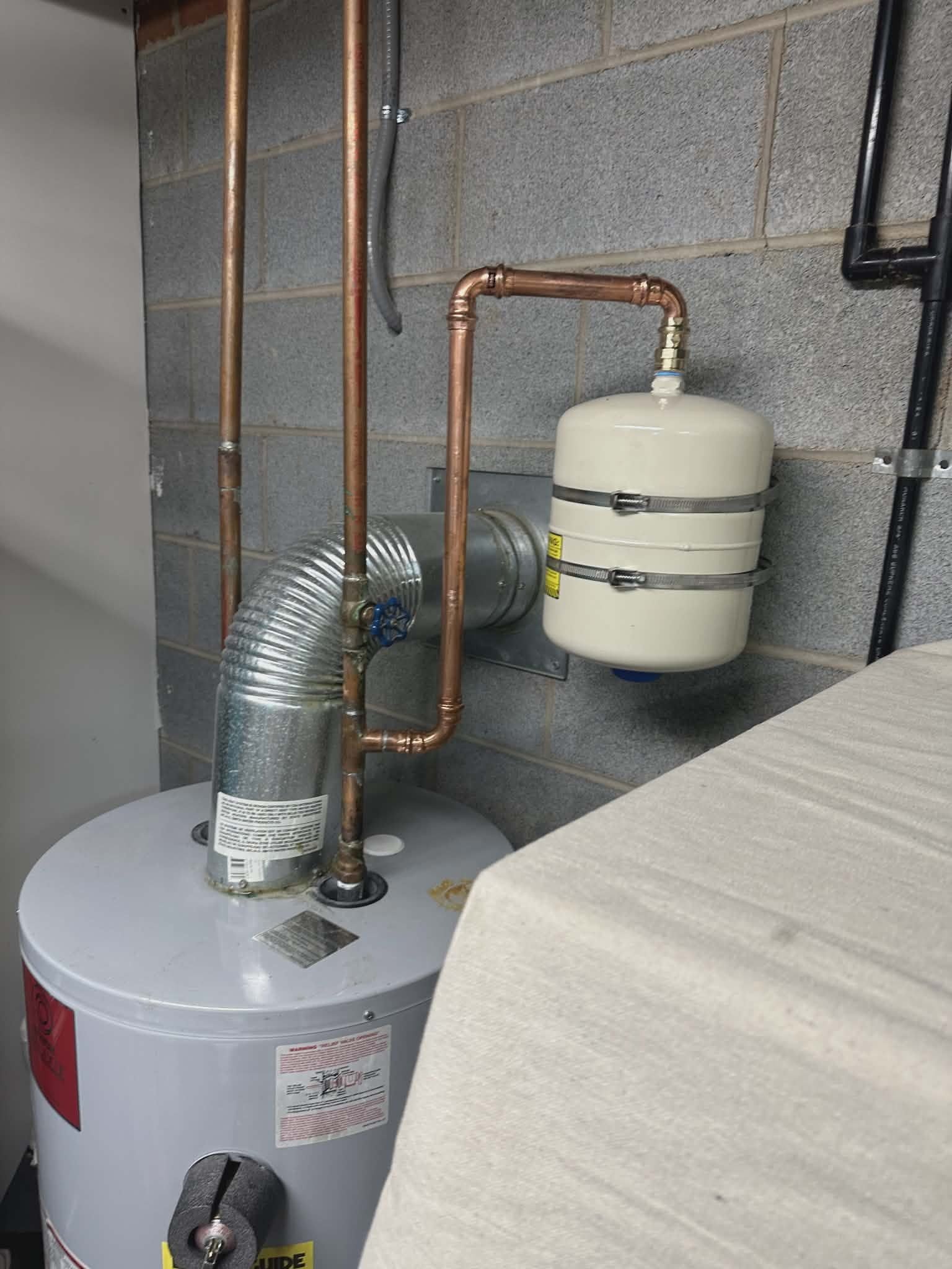 Expansion tank and copper piping installed as part of a code-correct water heater replacement