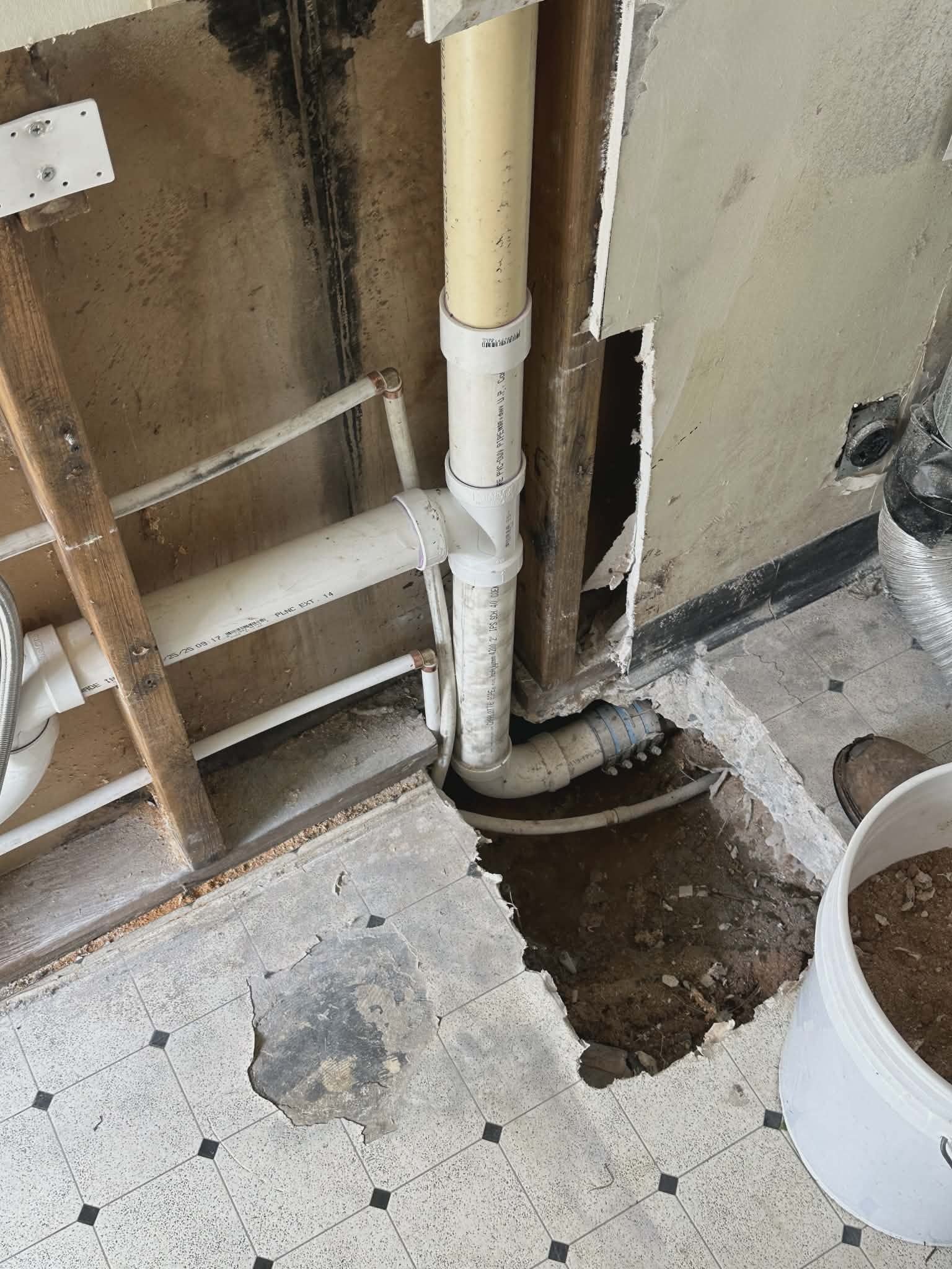 Subfloor drain pipe repair in a crawlspace to keep water moving away from the home