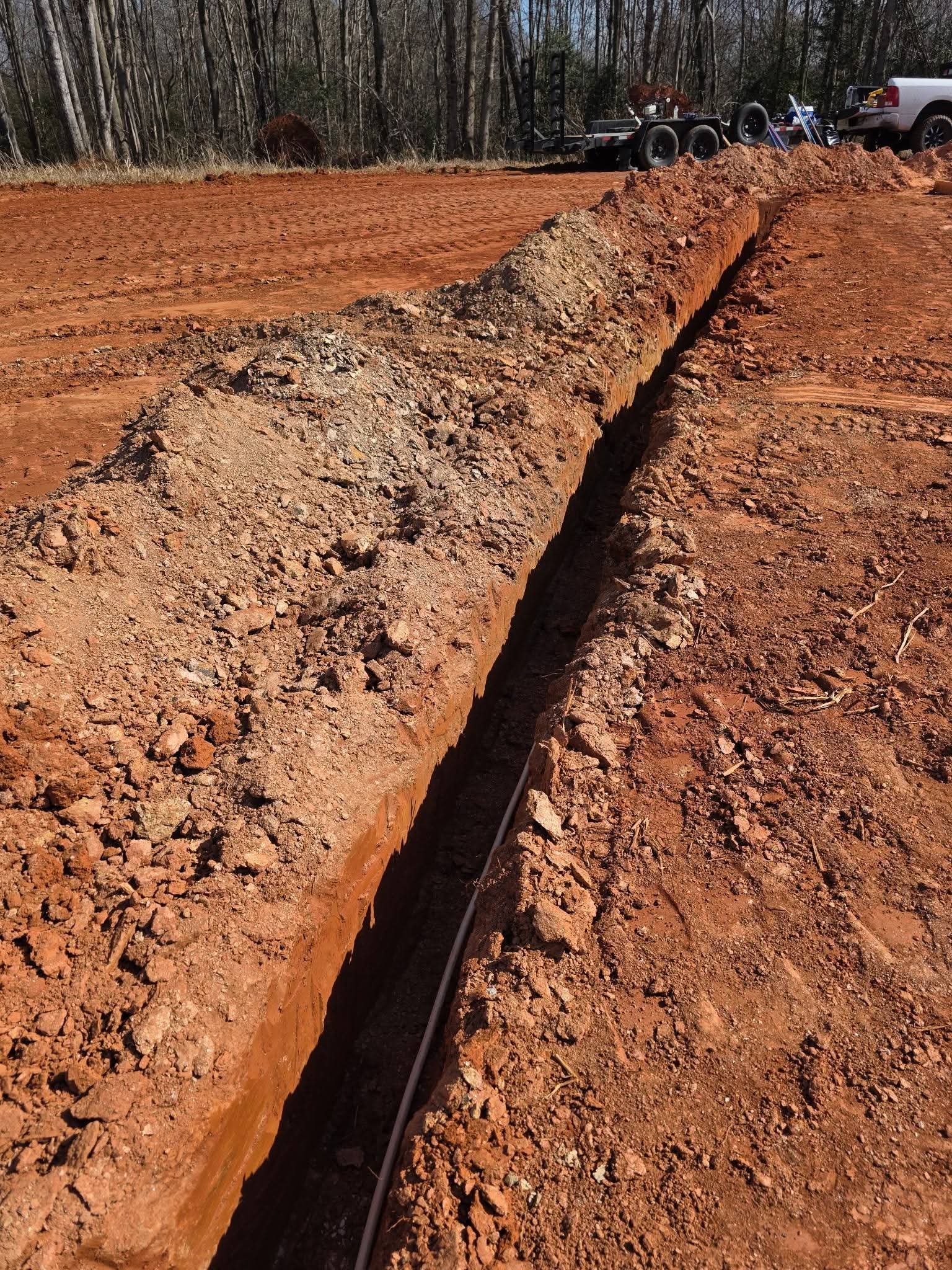 Exterior underground pipeline preparation with exposed earth and routing path for incoming or outgoing residential lines.