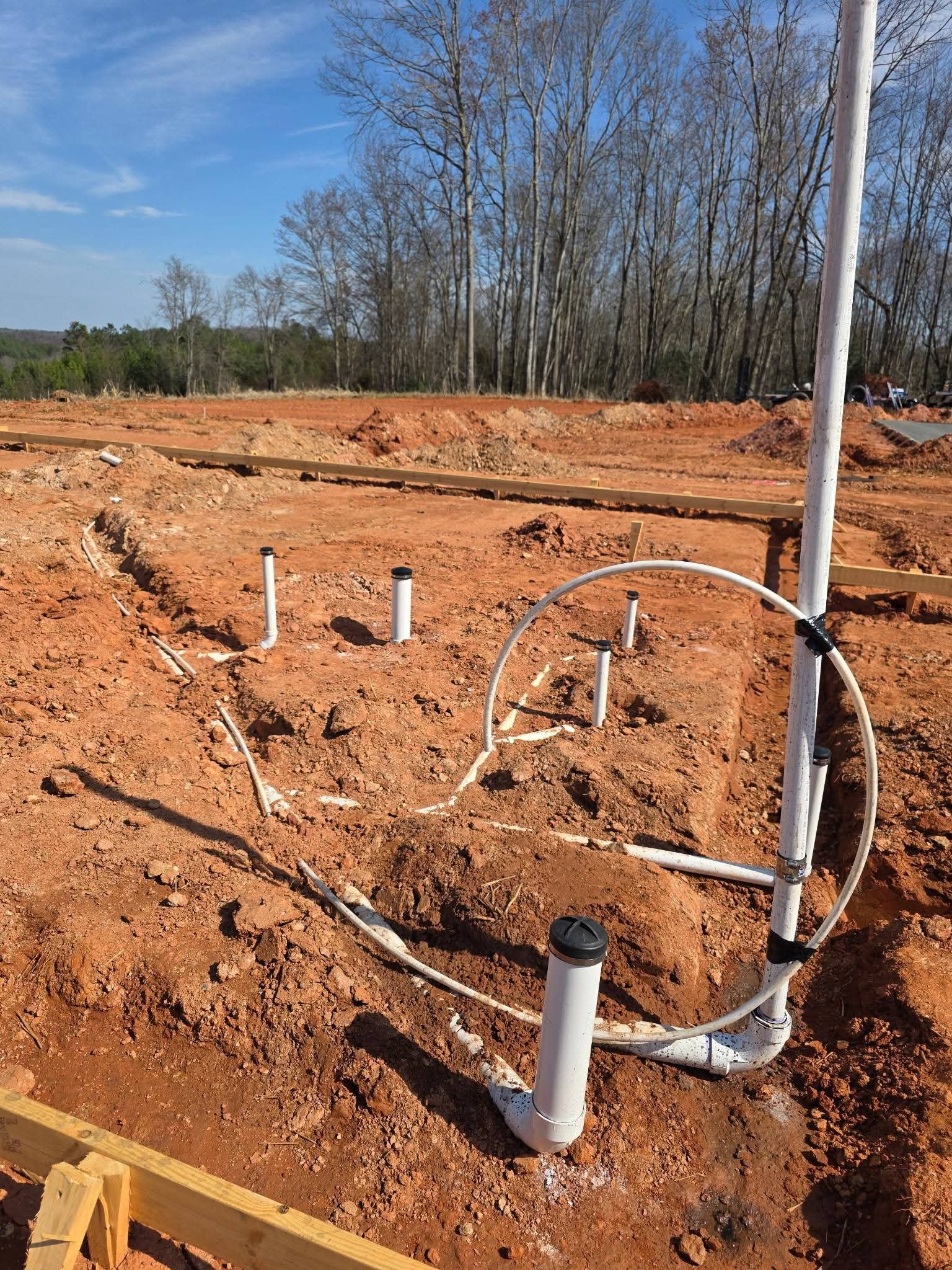 Residential underground plumbing run showing pipe joints and bedding for long-term leak resistance in Yadkin County.