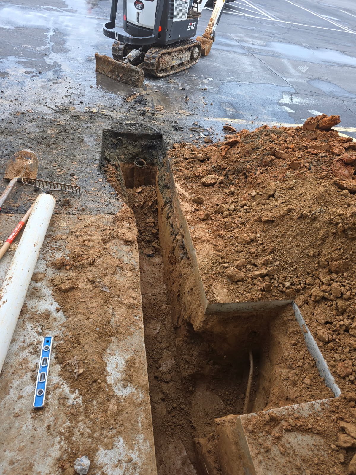 Exterior underground pipeline prep for a commercial gym in Yadkinville, NC, with trenching sized for high-use restrooms and equipment drains.
