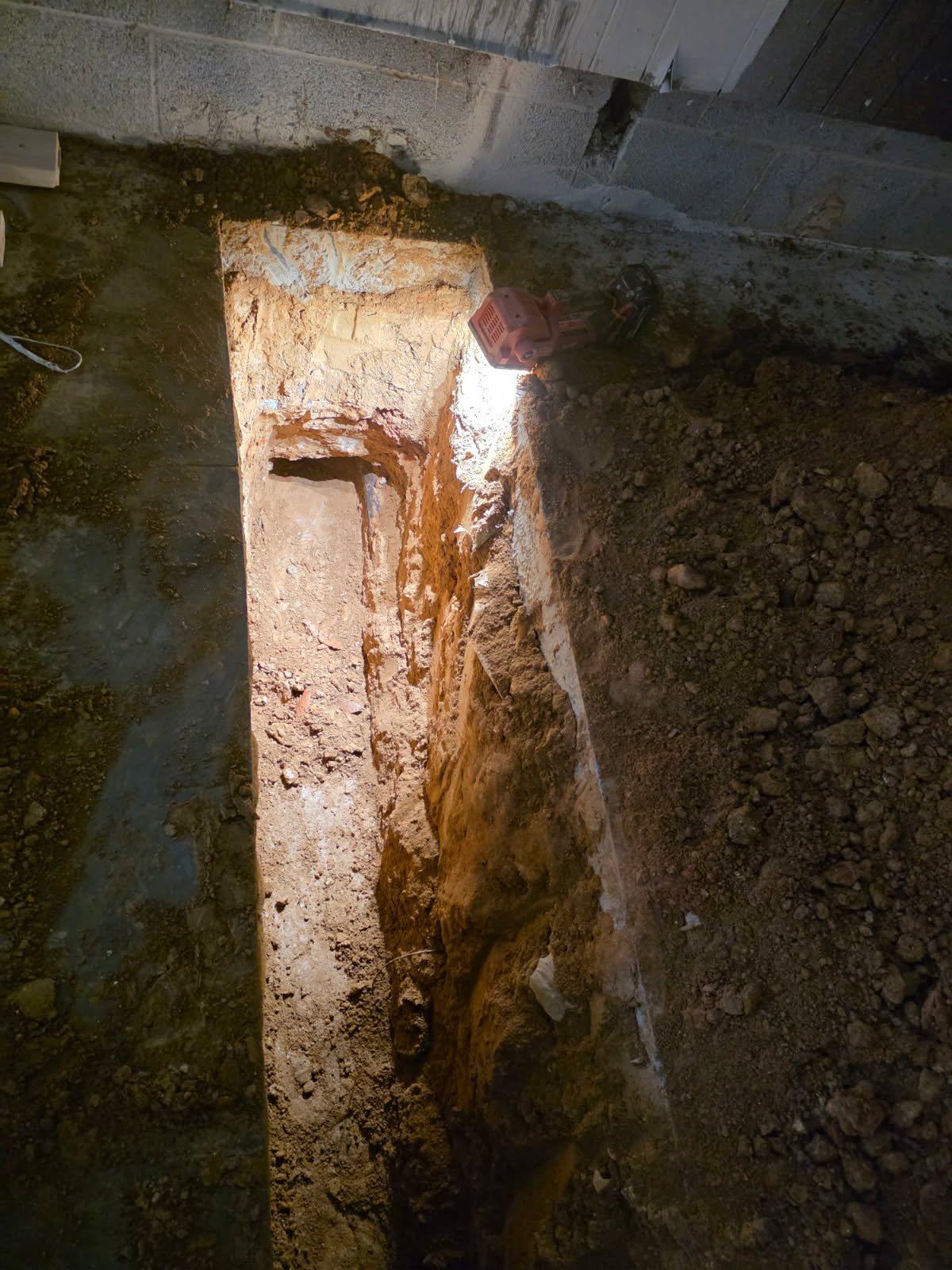 Interior trench and pipeline prep for commercial-grade underground plumbing beneath a gym floor system.