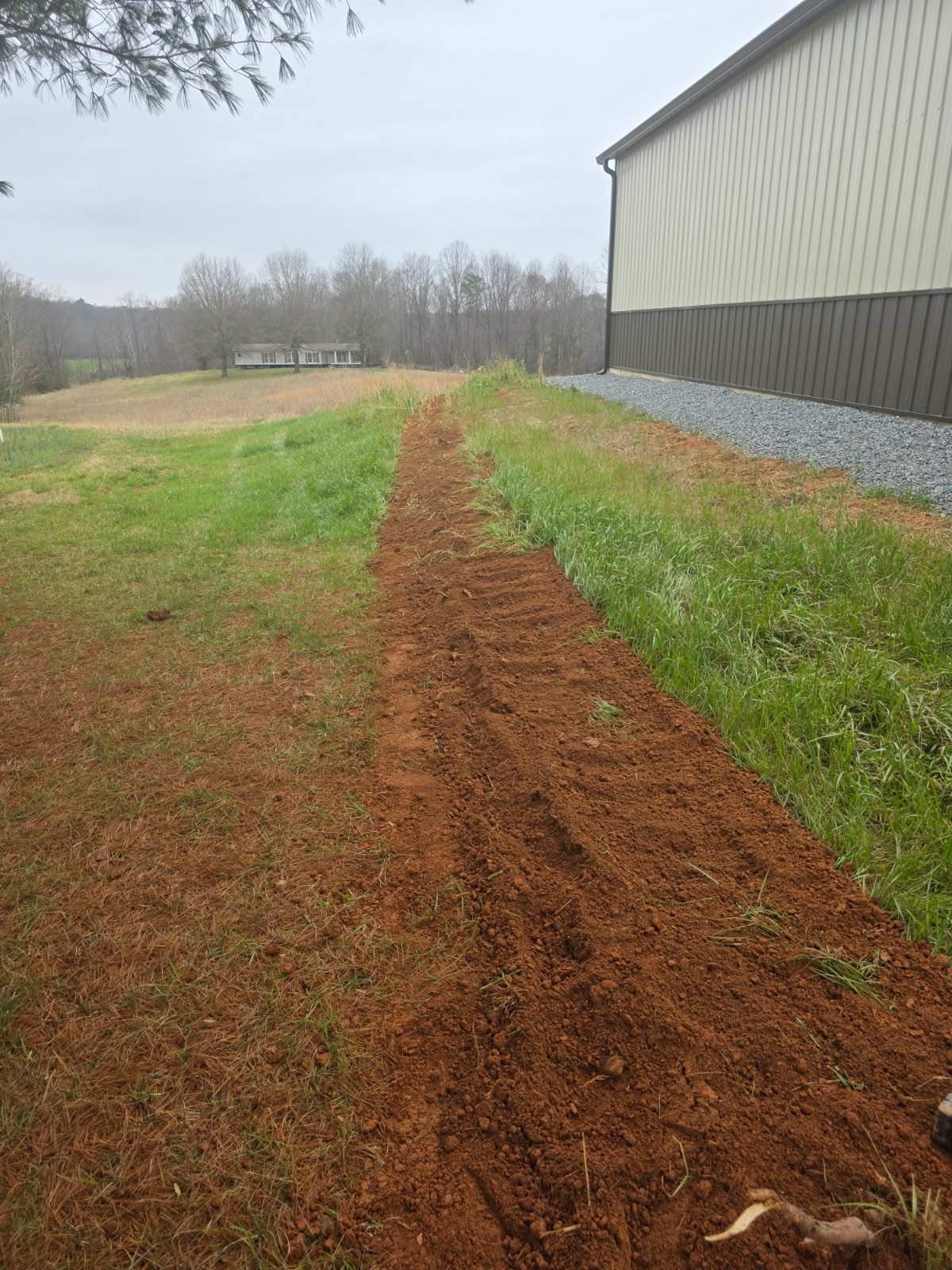 Long run of concealed underground pipeline with restored grade after waterline installation by Burcham's Plumbing.
